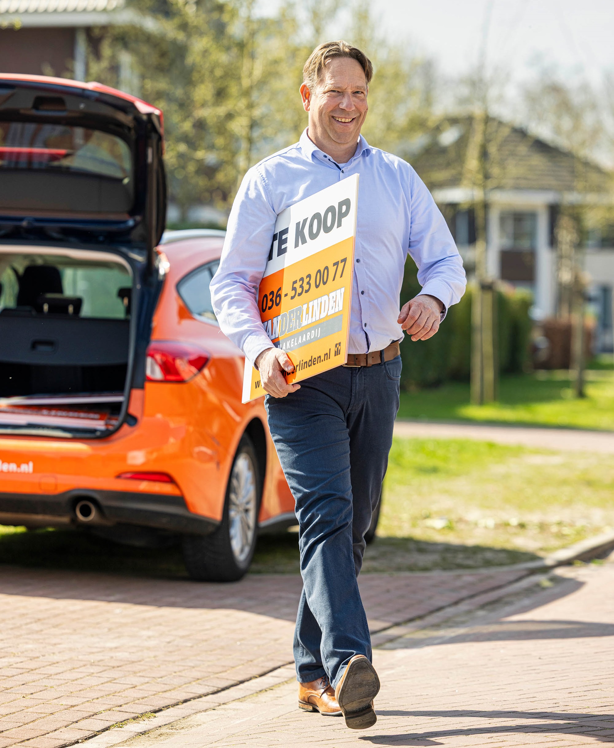 Realtor with for sale sign