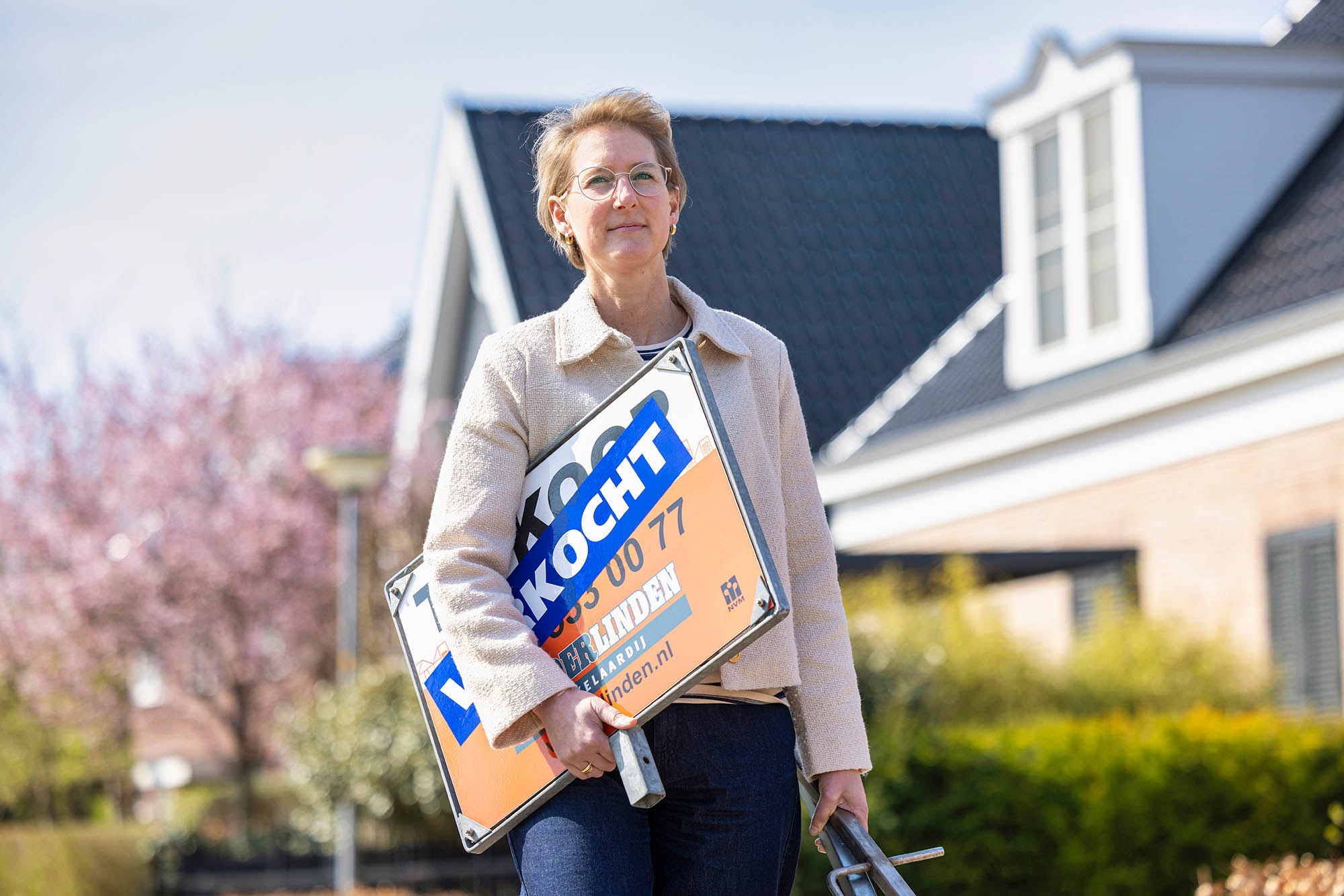 Claudia (broker) with a sold sign